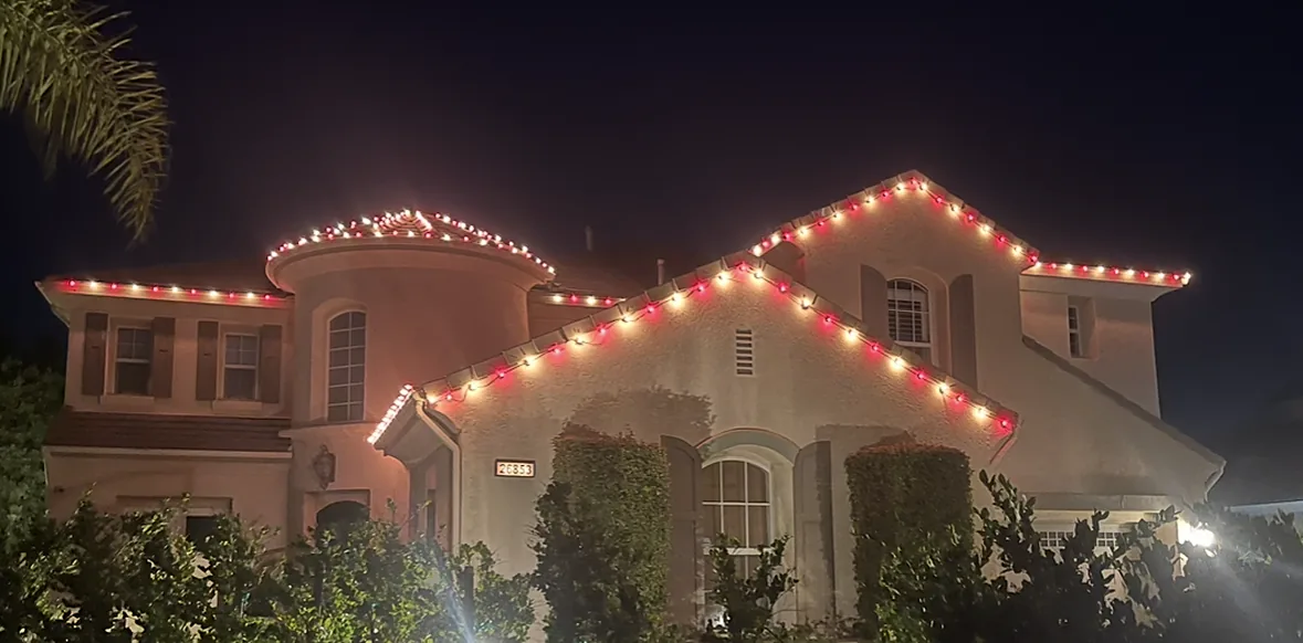 Residential Christmas Lights in Houston: turret and gables outlined in red and white Christmas lights